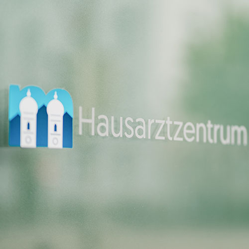 Glastür mit Logo des Hausarztzentrums – Hausarzt München