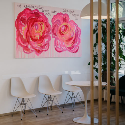 Wartebereich mit Rosenbild und weißen Stühlen – Hausarzt München